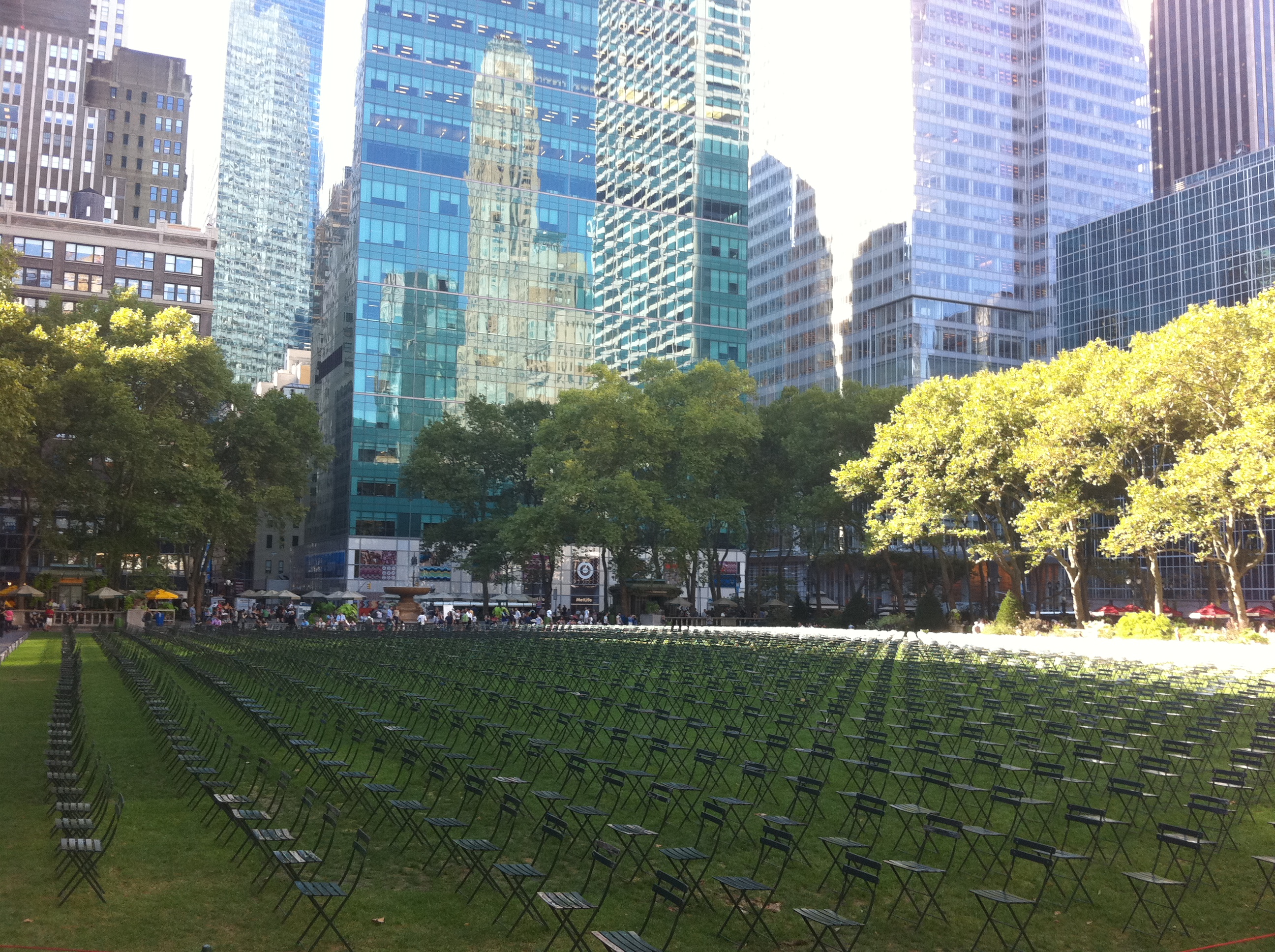 Rows of empty green chairs covering the Bryant Park lawn during the 2011 September 11 memorial installation, aligned toward the World Trade Center site.